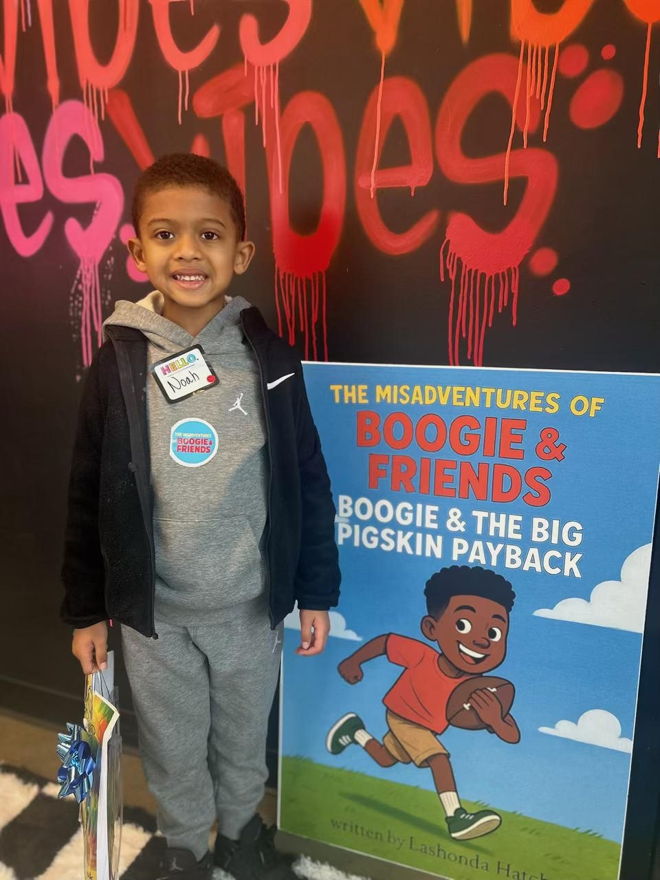 Young reader posing with Boogie & Friends sign